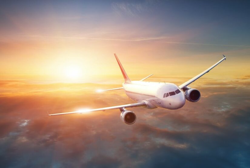 Flugzeug über den Wolken bei Sonnenuntergang