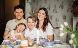 Eine glückliche Familie, die an einem Tisch sitzt.