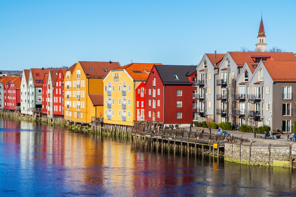 Panoramablick auf alte farbenfrohe Holzhäuser mit Spiegelungen im Fluss in Trondheim, Norwegen