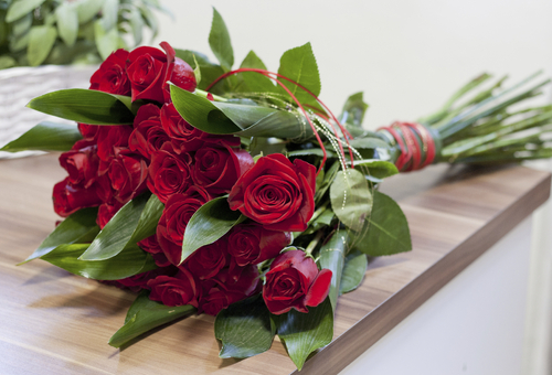 rote Rosen auf einem Holztisch