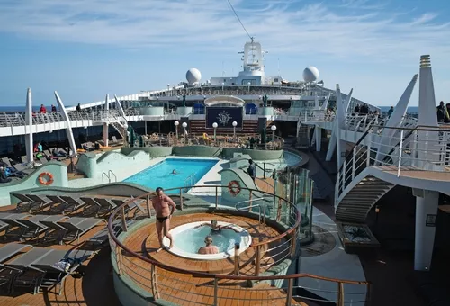 Deck eines Kreuzfahrtschiffs mit Pool und Sonnenliegen