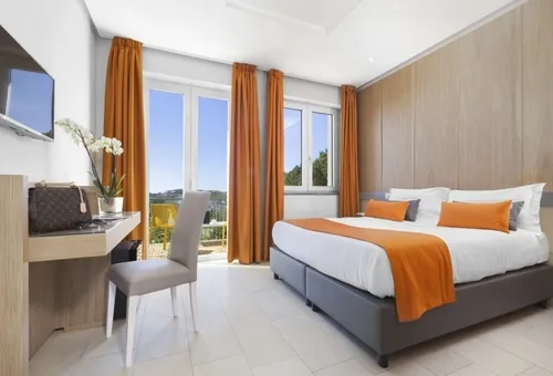 Modernes Hotelzimmer im O Sole Mio in Sant’Agata sui Due Golfi mit Doppelbett, Sitzbereich und großen Fenstern mit Tageslicht