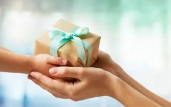 Eine Hand vergibt an eine andere Person ein Geschenk